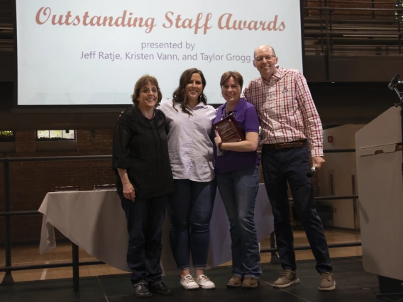 Group photo of award recipient and award presenters on stage