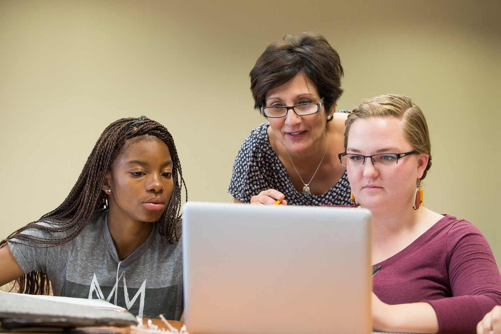 Teacher and students looking at a computer